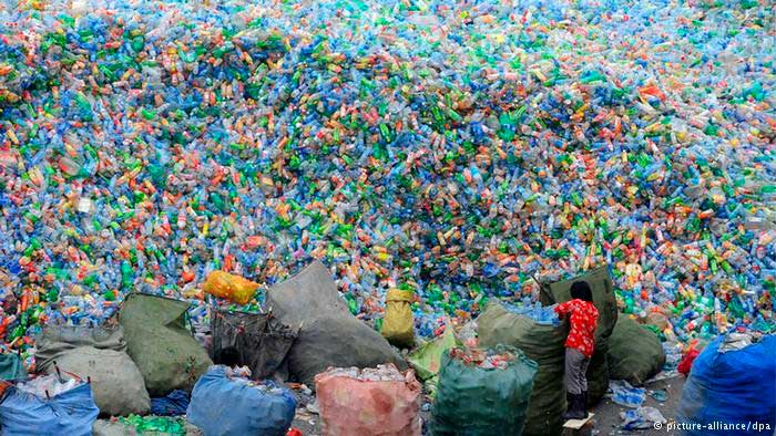 Trabajador chino frente a una gran “montaña” de botellas de plástico en un centro de reciclaje ubicado en la ciudad de Zhengzhou, Henan – China 2010. / foto: dw.de